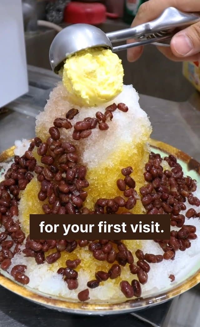 A mountain of fresh shaved ice topped with red beans and a yellow scoop — for your first visit.